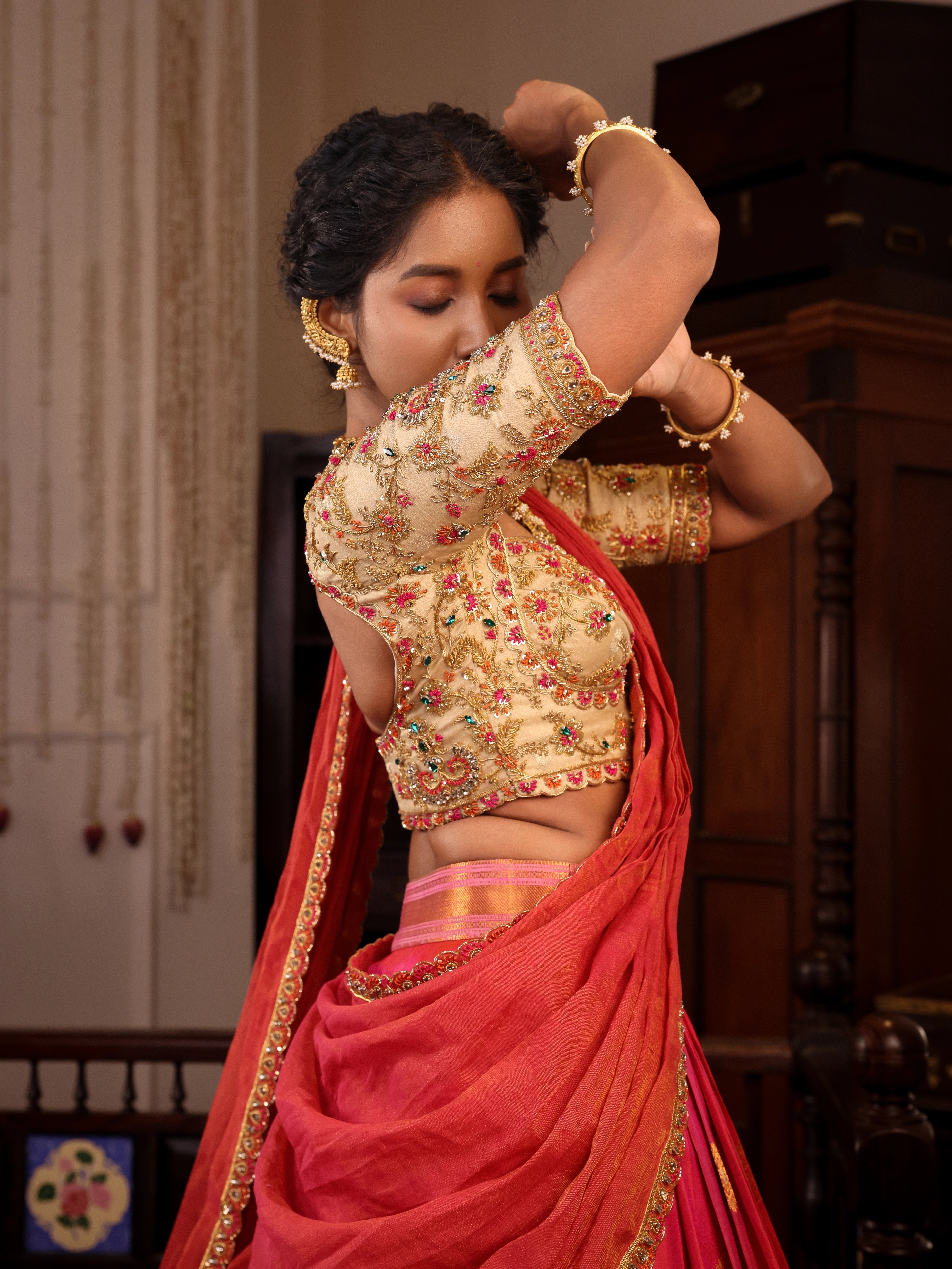 Model Gayathri Dhanasekar poses in  ivory and pink silk half saree blouse with jewelry by vummidi bangaru jewellers