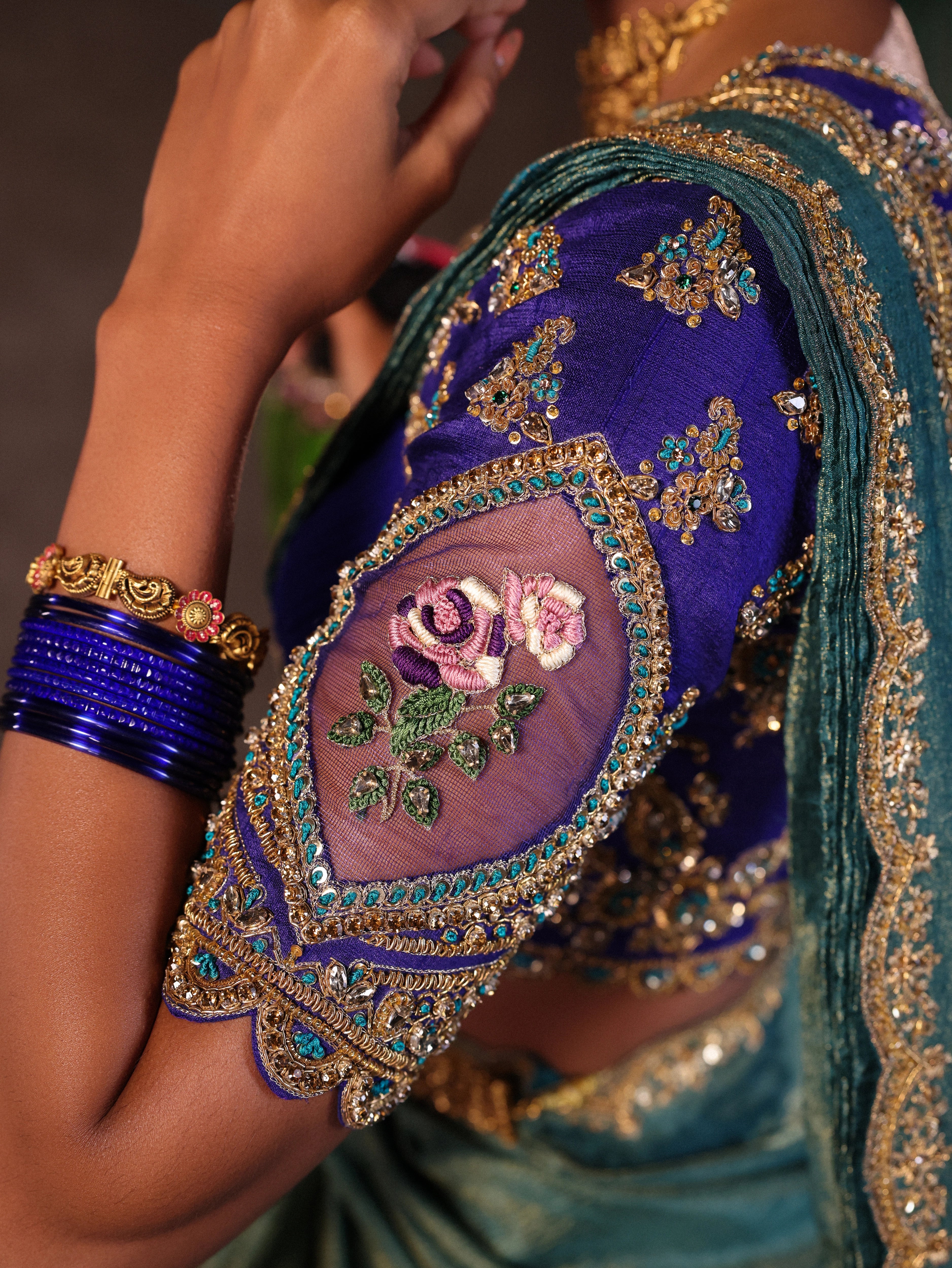 Model Gayathri Dhanasekar in blue banarasi brocade silk half saree blouse sleeves with glass bangles and NAC jewellery.