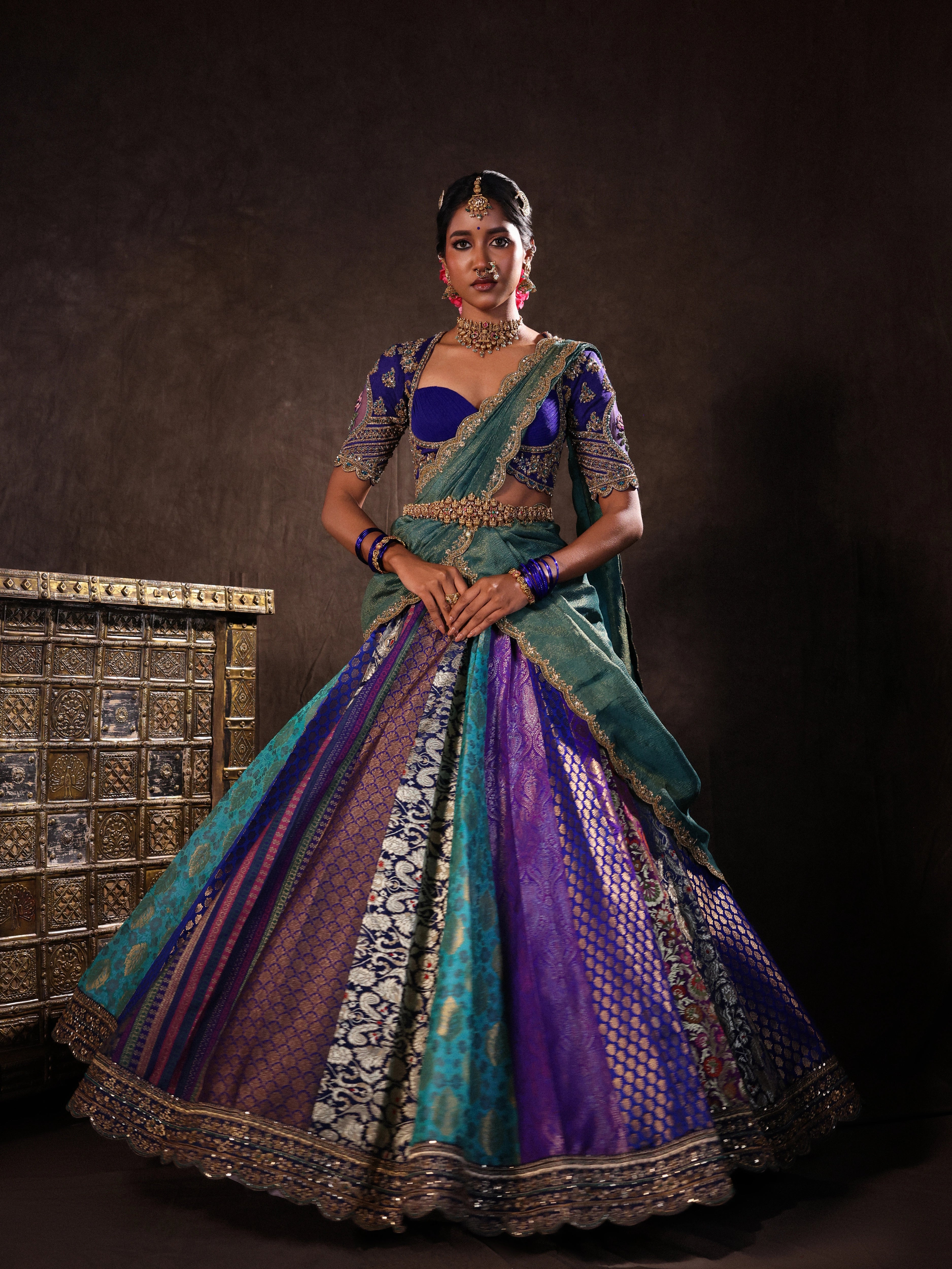 Model Gayathri Dhanasekar twirling in blue banarasi brocade silk half saree with glass bangles and NAC jewellery.