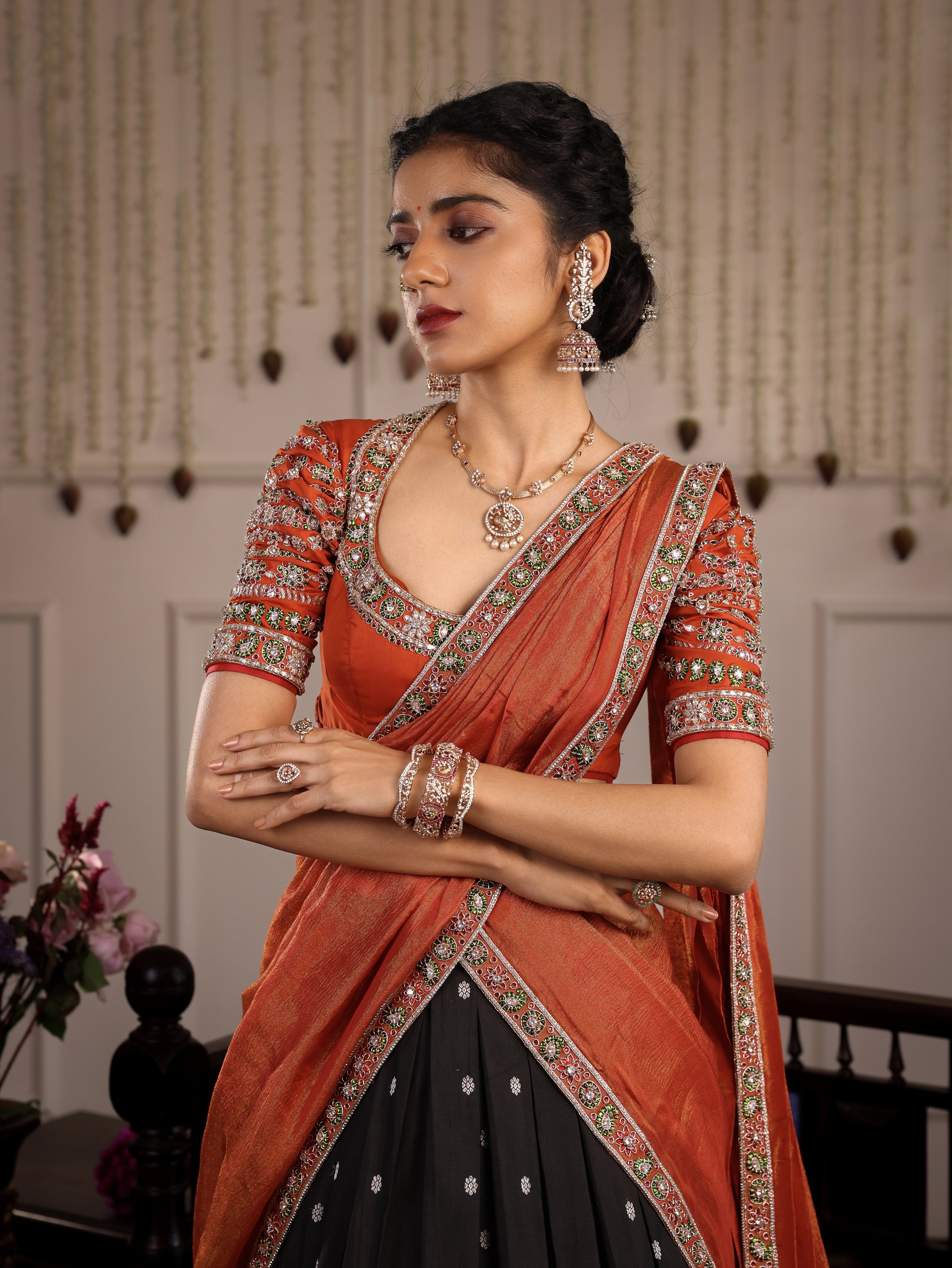 Model Himanshi posing in black & orange kanjeevaram silk half saree with vummidi bangaru jewllery