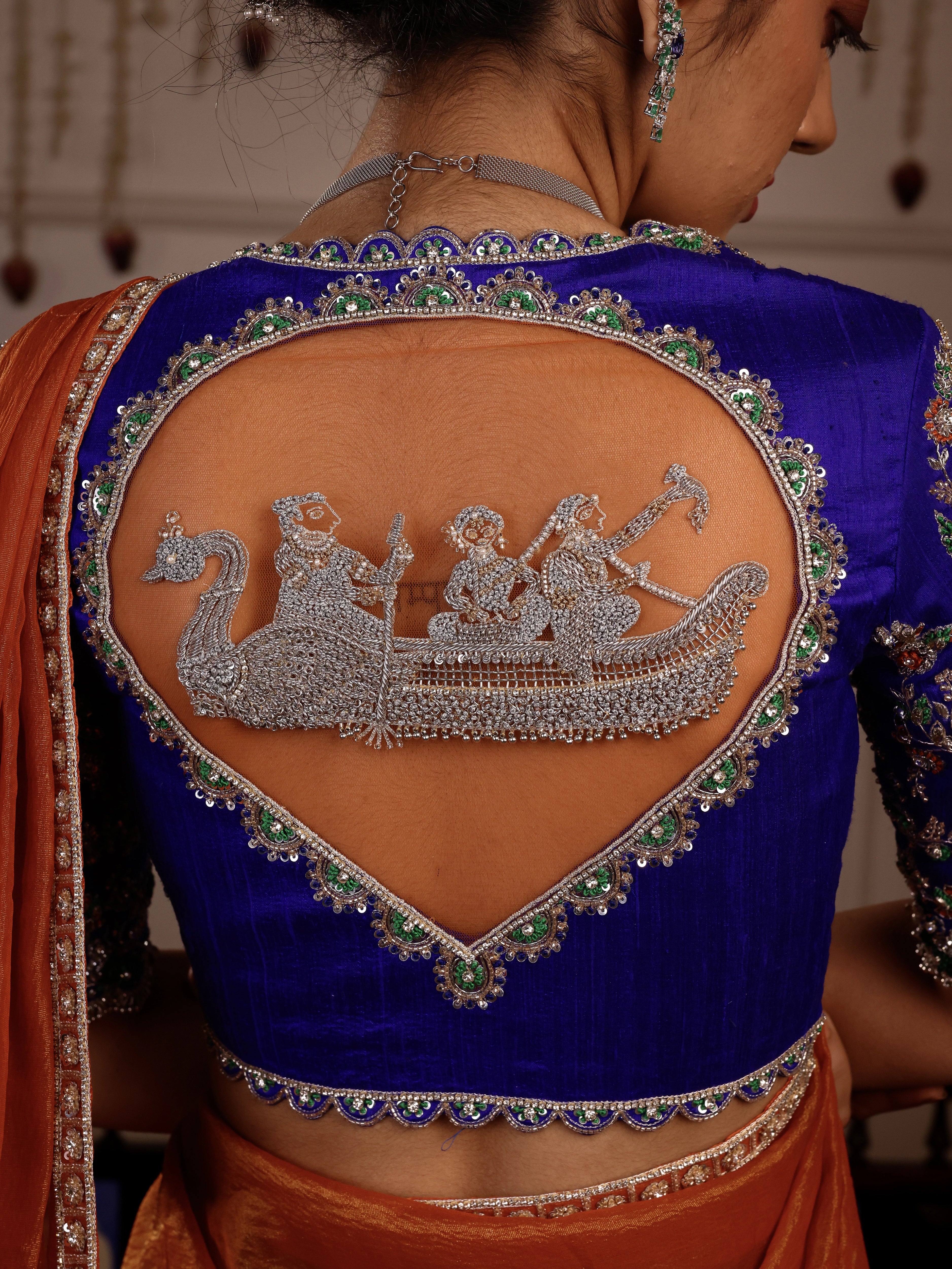 Model Himanshi posing in orange, blue & green sambalpuri silk half saree blouse back design with vummidi bangaru jewellery