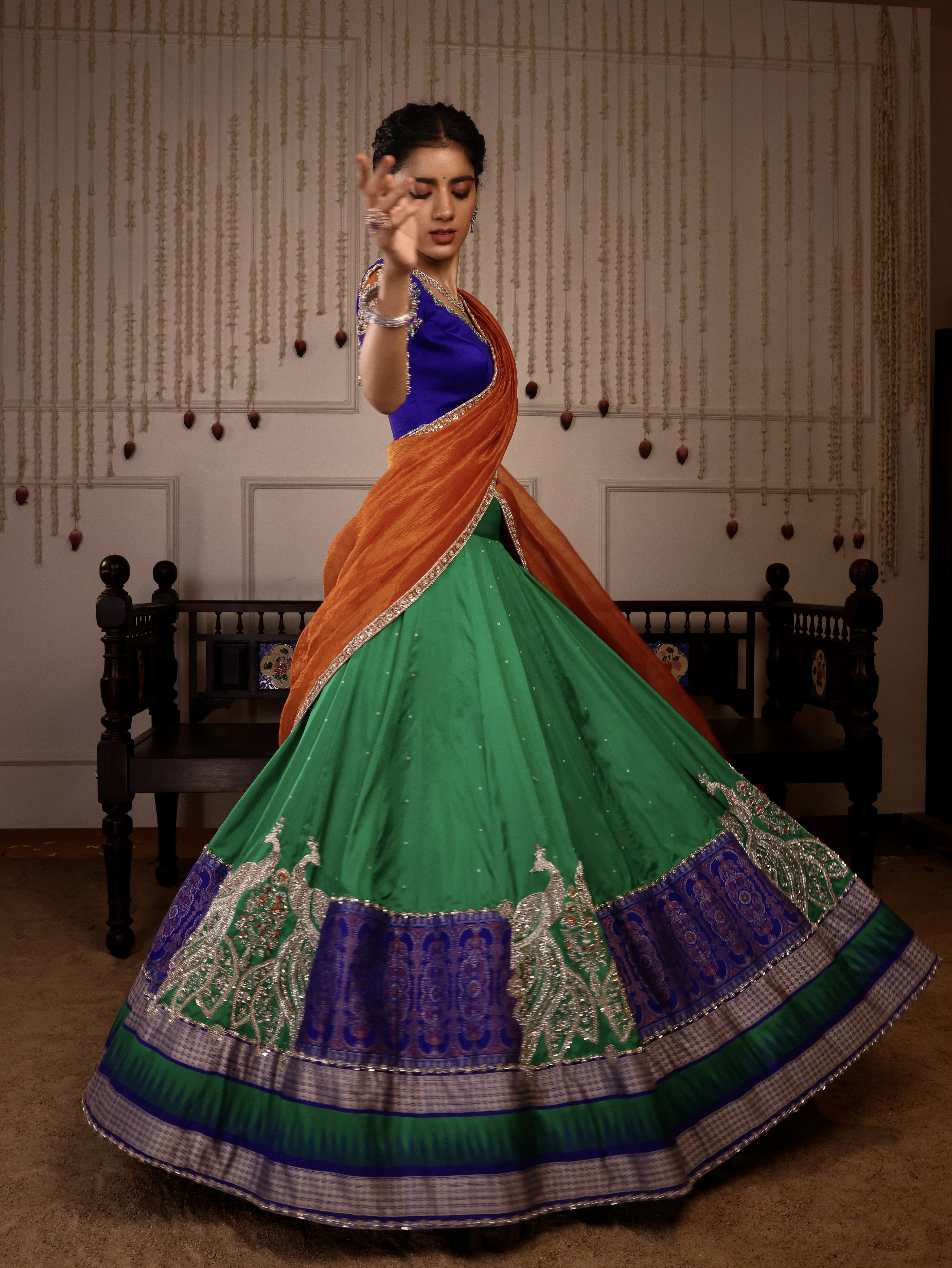 Model Himanshi twirls in orange, blue & green sambalpuri silk half saree with vummidi bangaru jewellery