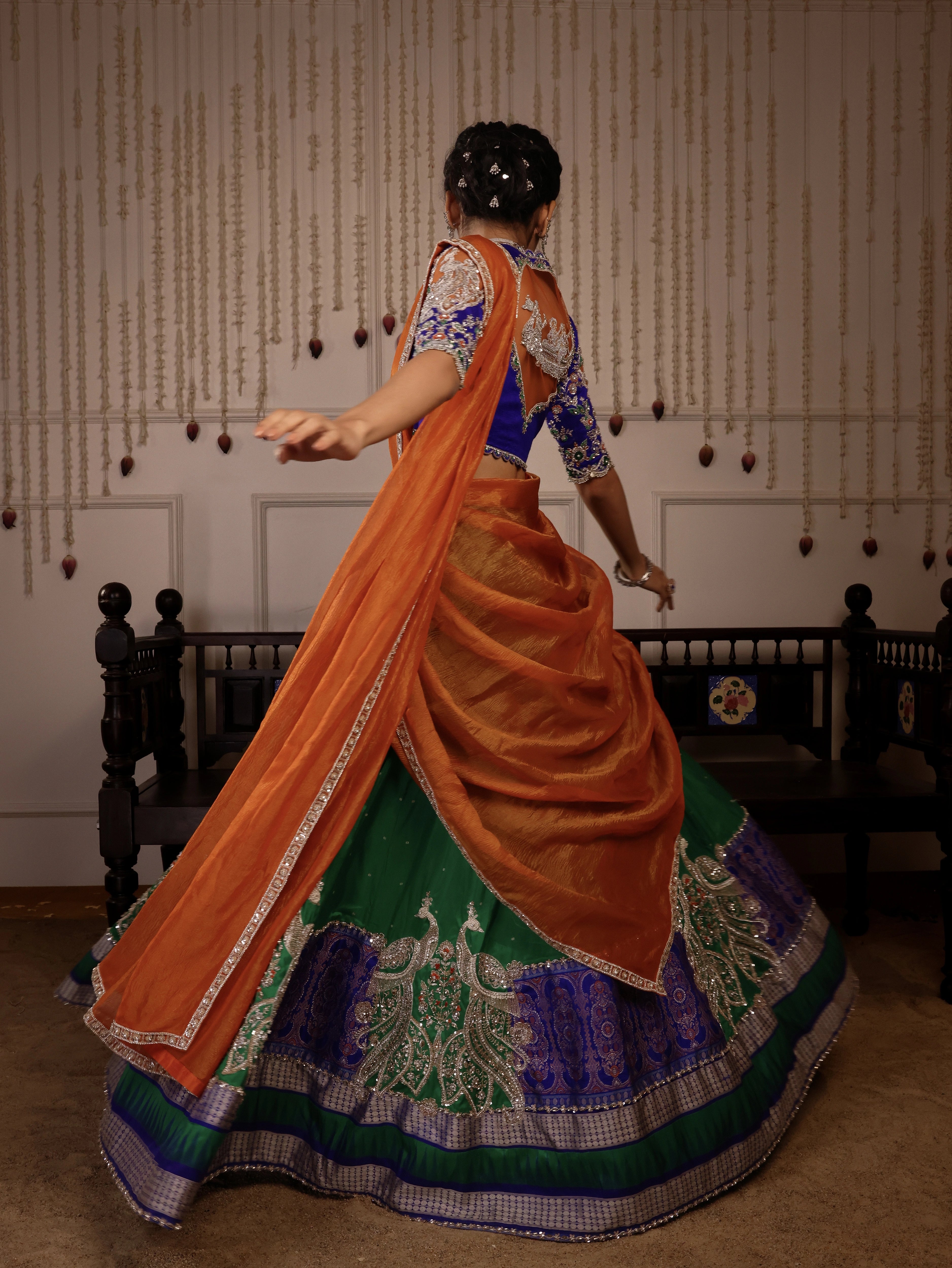 Model Himanshi twirling in orange, blue & green sambalpuri silk half saree with vummidi bangaru jewellery