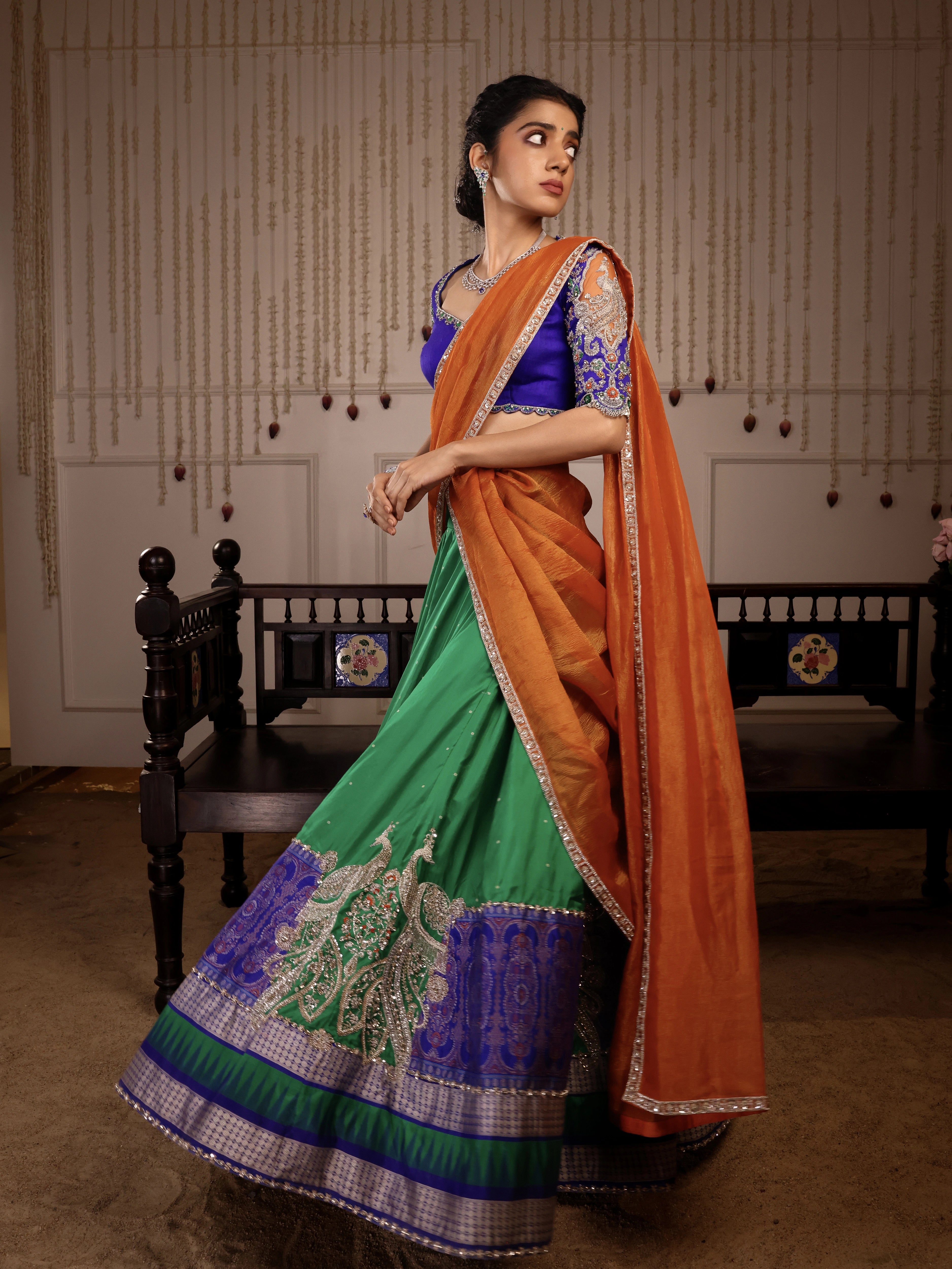 Model Himanshi posing in orange, blue & green sambalpuri silk half saree with vummidi bangaru jewellery