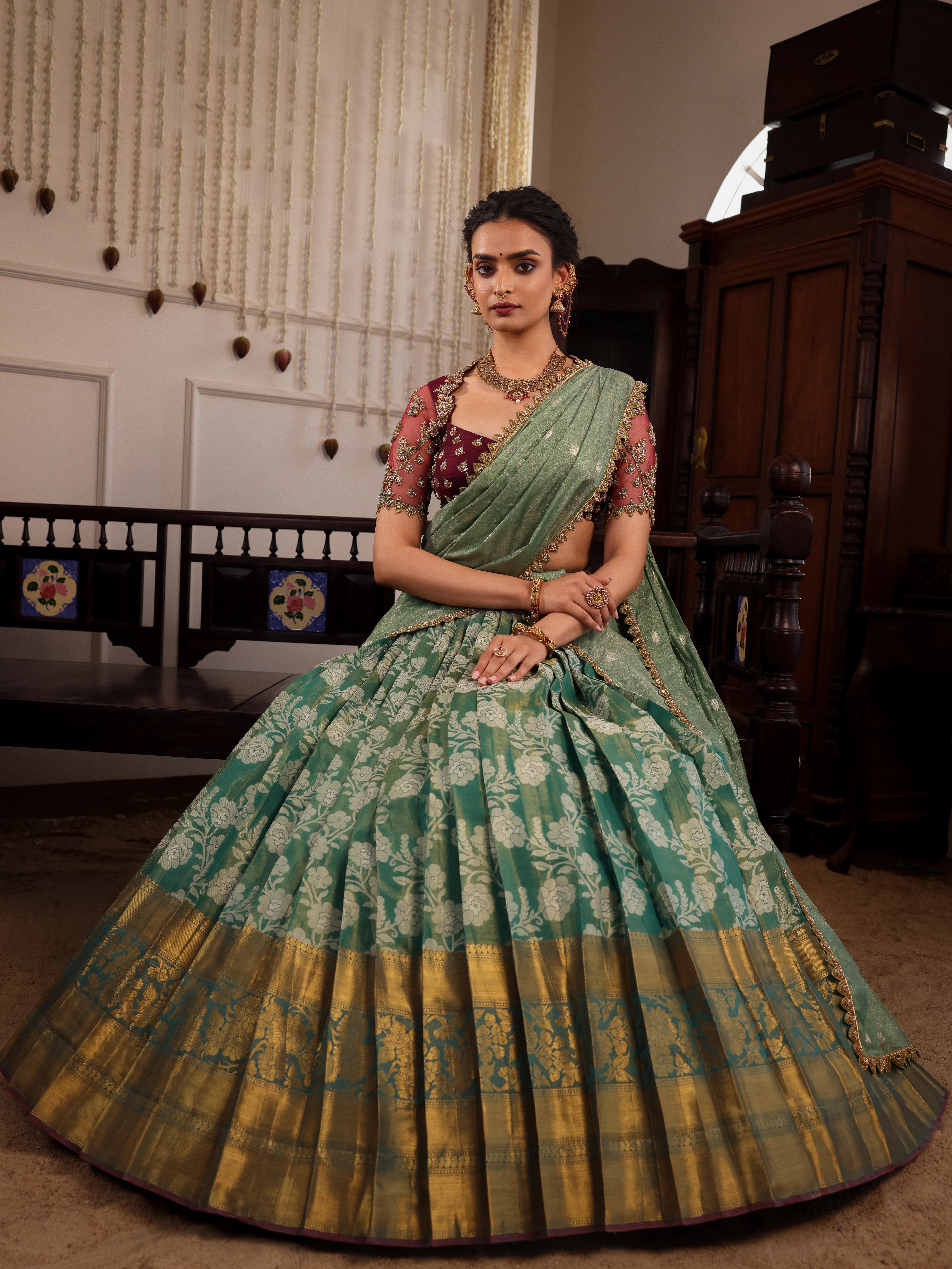 Model Sanskriti Mishra seated in sea green & wine red jacquard silk half saree with vummidi bangaru jewellery