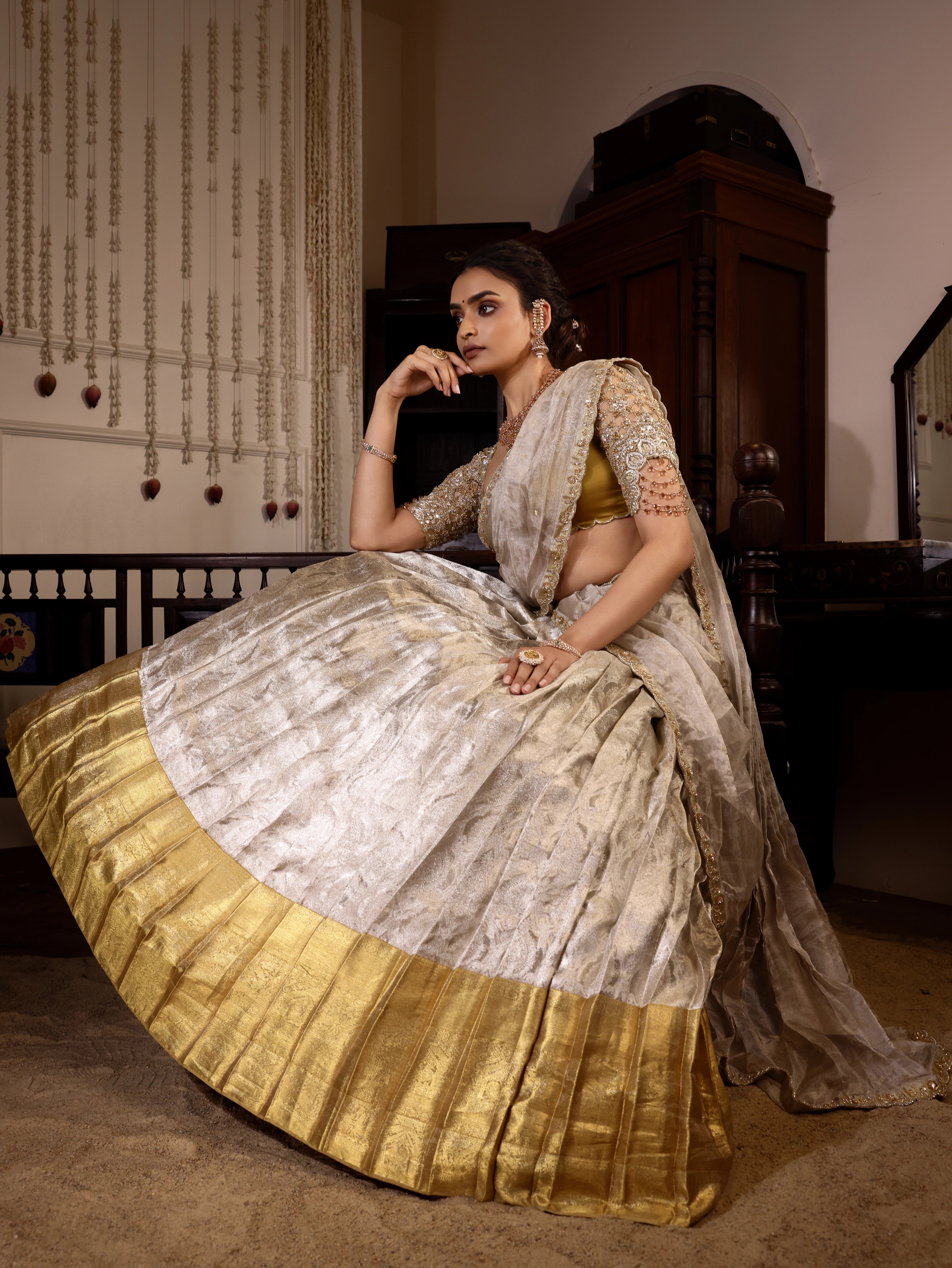 Model Sanskriti Mishra seated in gold and silver kanjeevaram silk half saree with vummidi bangaru jewllery