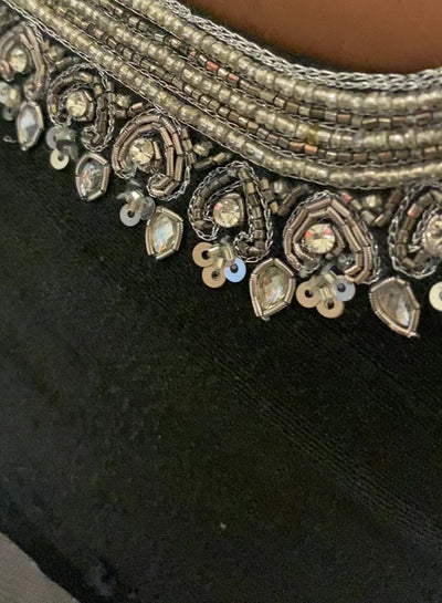 Bridesmaid Nagalakshmi in a video in a black rawsilk blouse, handcrafted by team Archana Karthick.