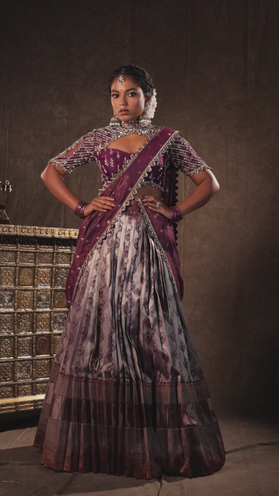 Model Ashika Crystal in a campaign video in a silk half saree set in purple, handcrafted with zardozi, sequins and rhinestones. Team Archana Karthick completed the style with purple glass bangles, a ring, jhumkas, nose ring and a maang tikka.
